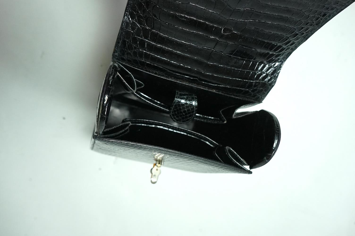 A stylish 1930’s lady’s Asprey of London, black lizard skin evening bag with ornamental amber coloured Bakelite clasp. 23cm high from handle to base. Condition- some internal scratches to lining as expected for age and u